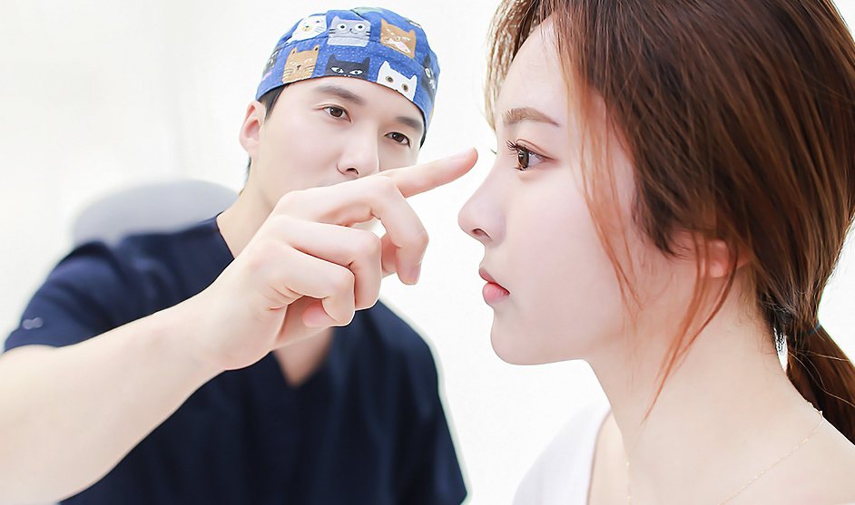 수술모 쓴 원장이 환자의 코를 손가락으로 가리키는 상담 장면