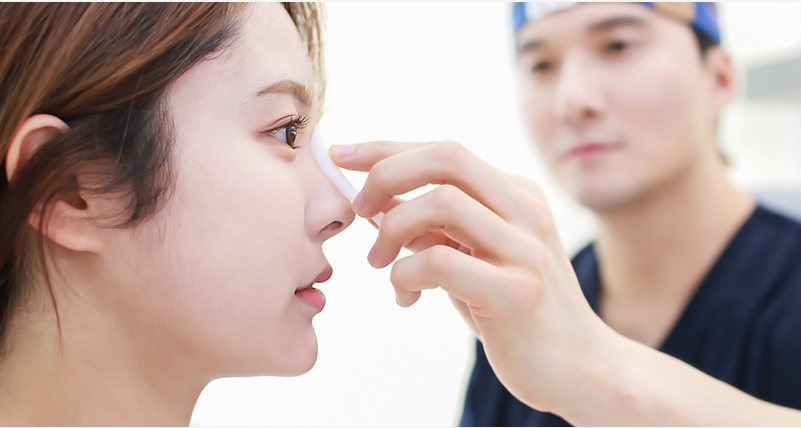 원장이 환자의 코를 손으로 살펴보는 장면